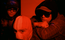 Kneecap pose in a press shot with a red hue