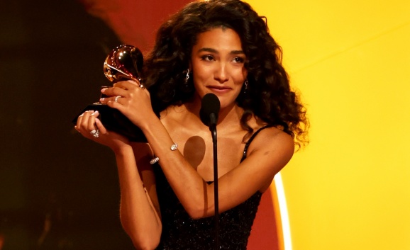 Olivia Dean wears and black dress and accepts her 2026 Grammy award for Best New Artist